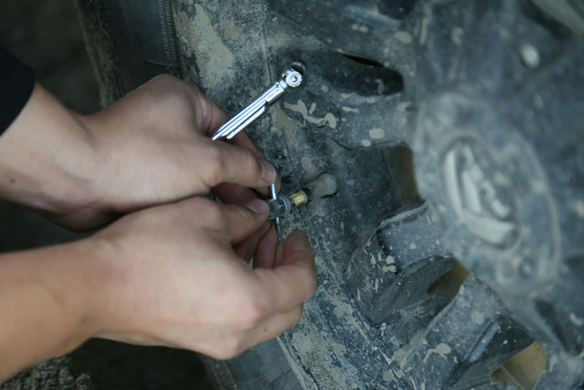 changing-flat-tyre person putting on a pin on vehicle tire